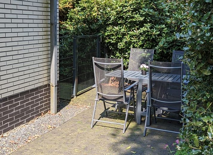 Gemuetliches Wohnzimmer des Ferienhauses in Beekbergen, Ferienhaus in der Veluwe, Gelderland, mit komfortabler Sitzecke und modernem Kamin.