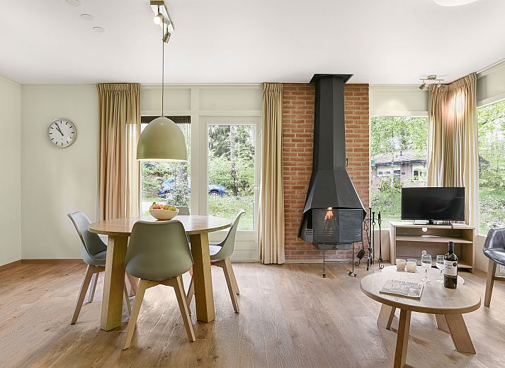 Gezellige woonkamer met open haard in Heideheuvel bungalow, Beekbergen, Veluwe, ideaal voor ontspanning.