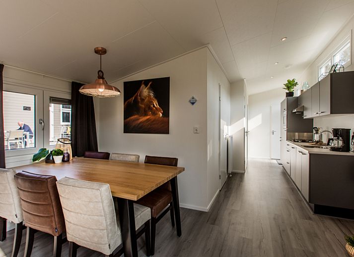 Gemuetliches Schlafzimmer im Ferienhaus Rialto fuer 6 Personen, Beekbergen, Veluwe. Bequemes Bett mit bunten Kissen und Blick auf die Natur.