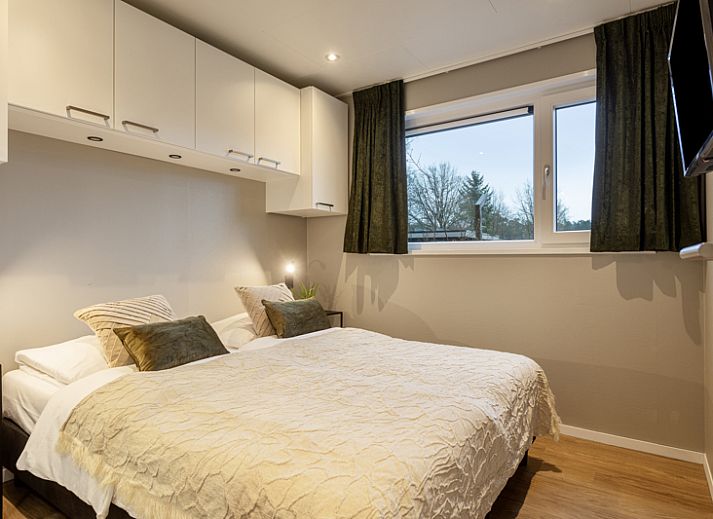 Belverdere 4-person vacation home in Beekbergen, Veluwe, Gelderland with modern veranda and green surroundings.