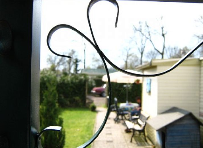 Veranda of Mobile home on the Veluwe in Harskamp, Gelderland with comfortable seating and green garden.