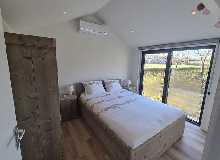 Ferienhaus in Harskamp auf der Veluwe, ein Ferienhaus inmitten der Natur in Gelderland mit einer sonnigen Terrasse und modernen Glasschiebetueren.