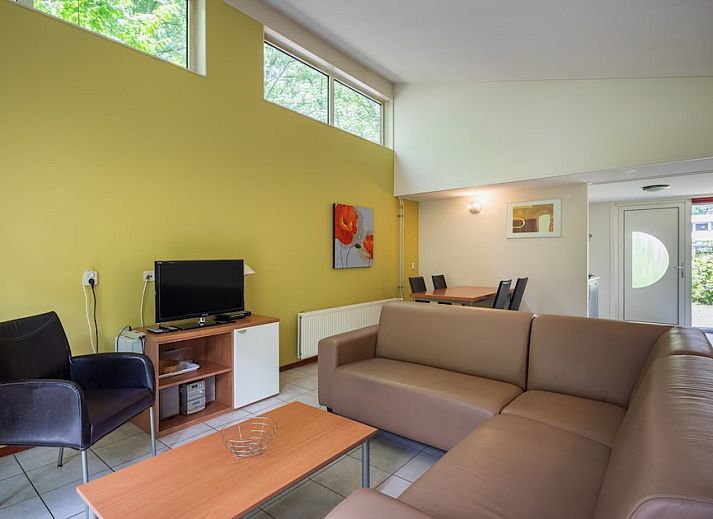 Gezellige woonkamer van Bungalow 4C in Kootwijk, Veluwe met uitzicht op terras en groene omgeving in Gelderland.