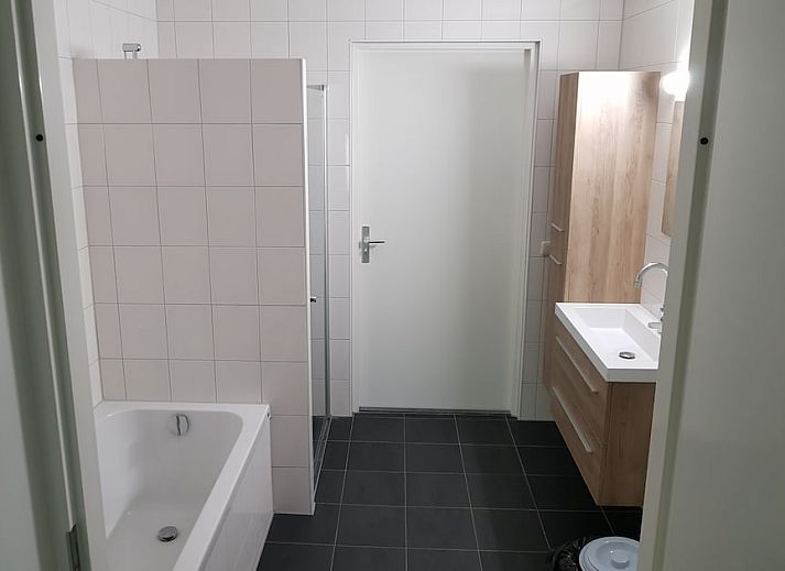 Gezellige woonkamer van Comfort Sauna 6C bungalow in Kootwijk, Veluwe, met uitzicht op het terras en de omliggende natuur.