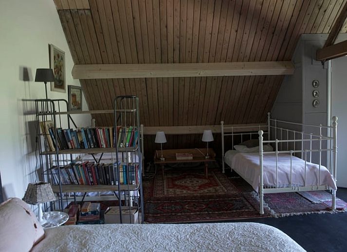 Sfeervolle slaapkamer in Huisje in Kootwijk, Veluwe, met comfortabel bed en rustieke details.