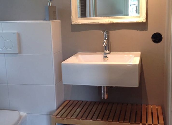 Sfeervolle slaapkamer in Huisje in Kootwijk, Veluwe, met comfortabel bed en rustieke details.