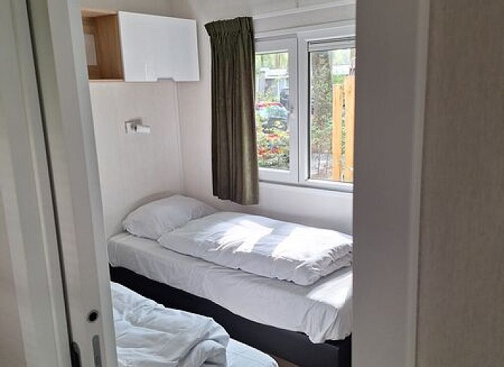 Gezellige slaapkamer van Module Flat Roof 4 personen in Ede, Veluwe, Gelderland, met grote ramen en comfortabel bed.