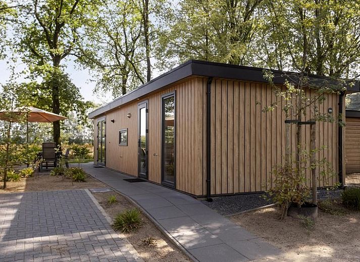 Module Wood 5 personen vakantiehuis in Ede Veluwe met houten gevel en terras in bosrijke omgeving.