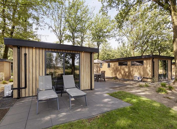Module Wood 5 personen vakantiehuis in Ede Veluwe met houten gevel en terras in bosrijke omgeving.