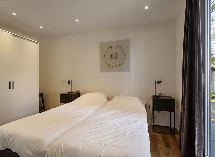 Module Wood 5 personen vakantiehuis in Ede Veluwe met houten gevel en terras in bosrijke omgeving.