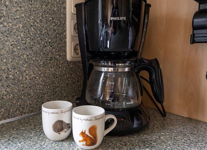 Dining area in Holiday home in Emst, Gelderland, with modern chairs and table.