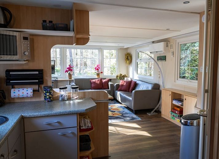 Dining area in Holiday home in Emst, Gelderland, with modern chairs and table.