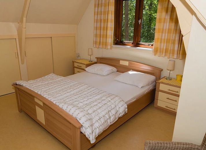 Vacation cottage in Emst with comfortable outdoor seating surrounded by green nature.