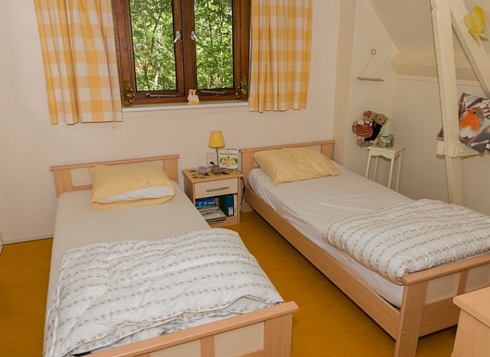 Vacation cottage in Emst with comfortable outdoor seating surrounded by green nature.