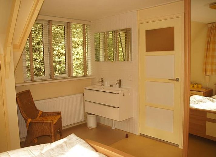 Vacation cottage in Emst with comfortable outdoor seating surrounded by green nature.