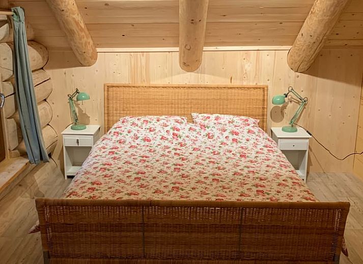 Gemuetlicher Innenbereich des Ferienhauses in Emst, Veluwe, Gelderland mit Holzinterieur und stimmungsvoller Beleuchtung.