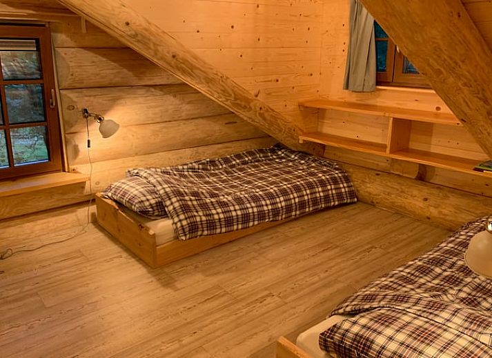 Gemuetlicher Innenbereich des Ferienhauses in Emst, Veluwe, Gelderland mit Holzinterieur und stimmungsvoller Beleuchtung.