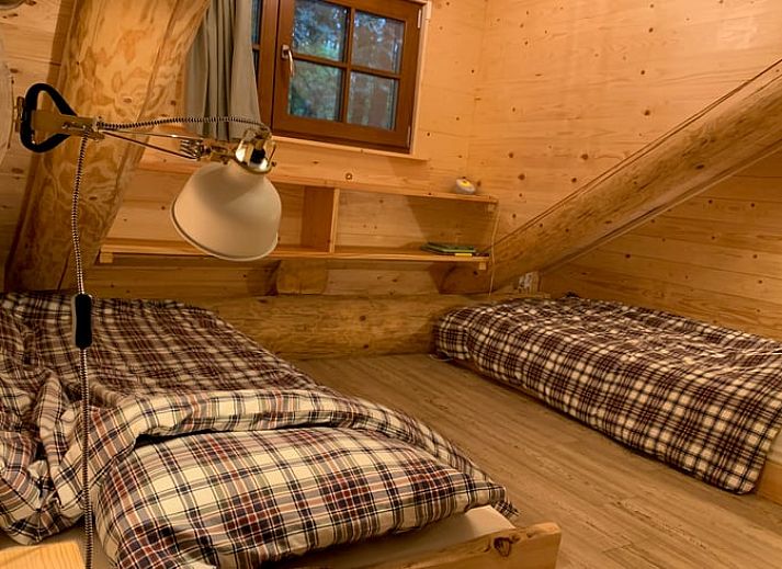 Gemuetlicher Innenbereich des Ferienhauses in Emst, Veluwe, Gelderland mit Holzinterieur und stimmungsvoller Beleuchtung.