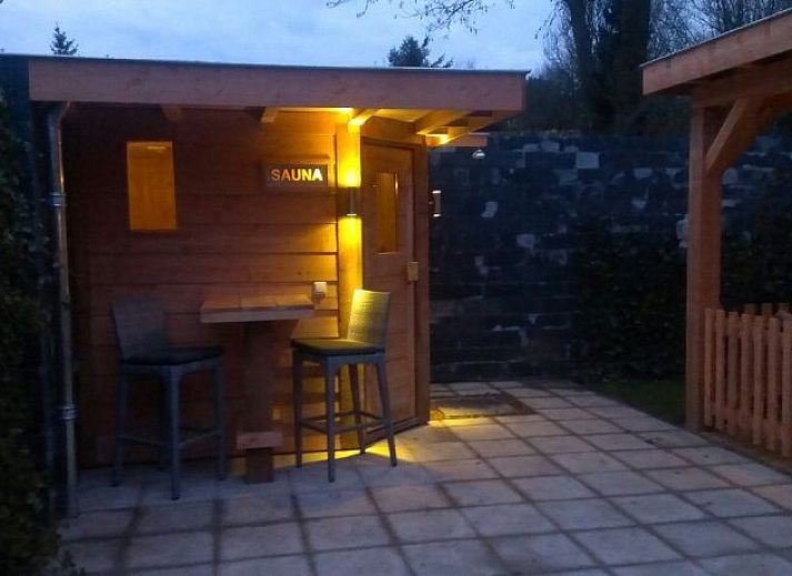 Aussenansicht des Ferienhauses De Leuvenhorst in Harderwijk, Veluwe mit Terrasse und gruener Umgebung.