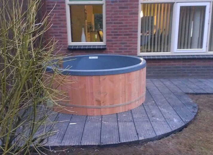 Aussenansicht des Ferienhauses De Leuvenhorst in Harderwijk, Veluwe mit Terrasse und gruener Umgebung.