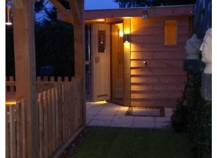 Aussenansicht des Ferienhauses De Leuvenhorst in Harderwijk, Veluwe mit Terrasse und gruener Umgebung.