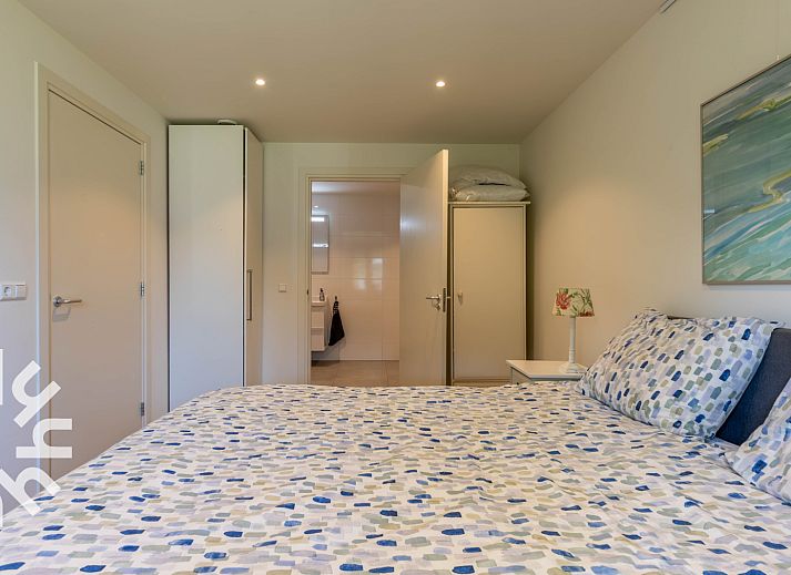 Ingang van vakantiehuis DG1560 in Ermelo, Veluwe, Gelderland, omgeven door groene hagen en schaduwrijke bomen.