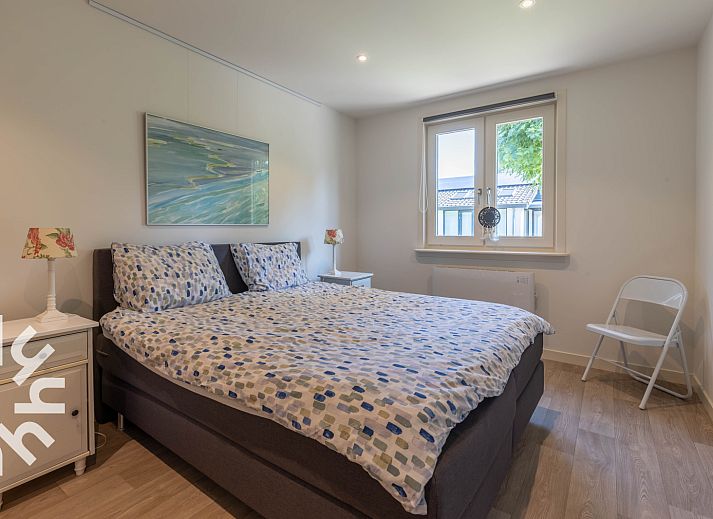 Geniet van de zonnige patio van vakantiehuis DG1560 in Ermelo, Veluwe, omgeven door weelderige natuur en rustgevende groene heggen.