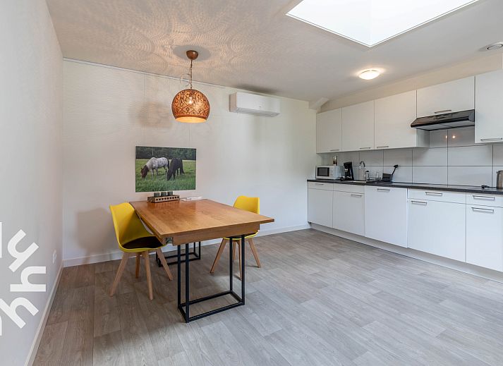 Geniet van de zonnige patio van vakantiehuis DG1560 in Ermelo, Veluwe, omgeven door weelderige natuur en rustgevende groene heggen.