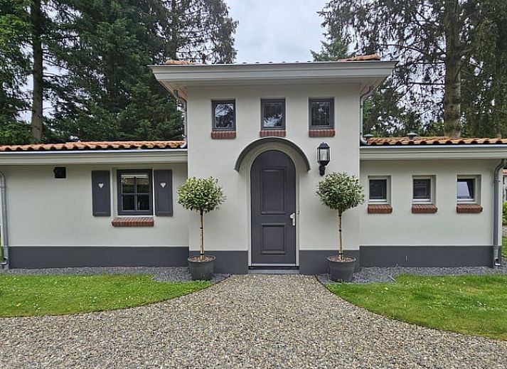 Charmantes Ferienhaus in Ermelo, Veluwe, Gelderland, umgeben von Natur mit einem einladenden Eingang und rustikaler Architektur.