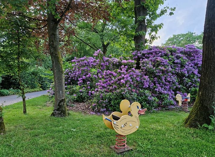Cozy living room of a cottage in Ermelo, Veluwe, Gelderland, with a view of the green garden and modern amenities.