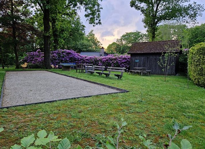 Cozy living room of a cottage in Ermelo, Veluwe, Gelderland, with a view of the green garden and modern amenities.