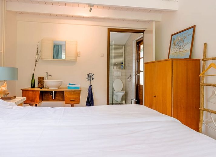 Gezellige woonkamer in Huisje in Ermelo, Veluwe, met kleurrijke stoelen en uitzicht op de natuur in Gelderland.