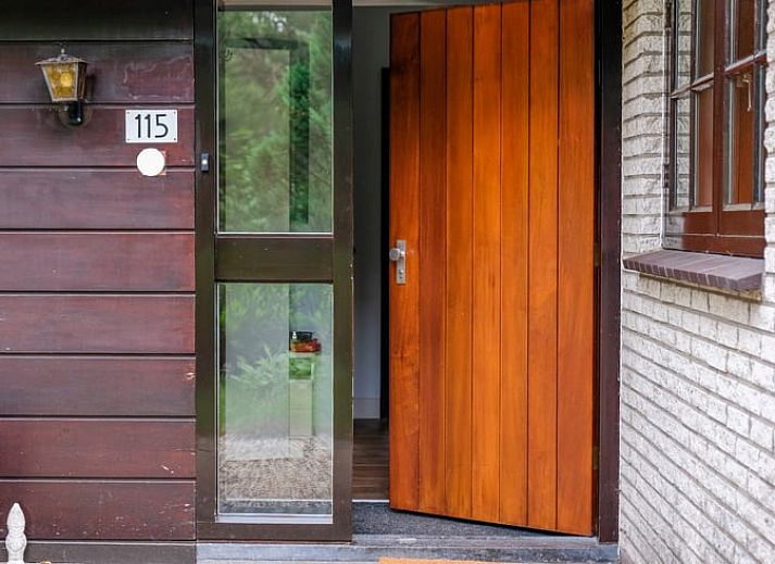 Gezellige binnenruimte van Huisje in Ermelo op de Veluwe, Gelderland, met een sfeervolle open haard en comfortabele stoelen.