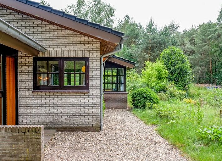 Gezellige binnenruimte van Huisje in Ermelo op de Veluwe, Gelderland, met een sfeervolle open haard en comfortabele stoelen.