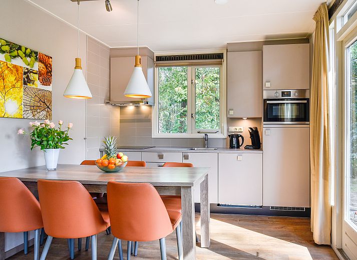 Gezellige woonkamer in Miggelenberg bungalow 6CE1, Hoenderloo, met uitzicht op de Veluwse natuur.