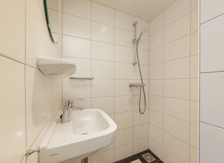 Gemuetliches Wohnzimmer der Veluwe Villa 4B in Hoenderloo mit modernem Kamin und Blick auf die Veluwe Natur.