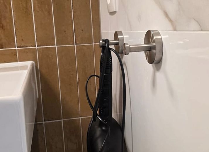 Gezellige binnenruimte van Vakantiehuis in Hoenderloo op de Veluwe, met comfortabele stoel en uitzicht op groene omgeving in Gelderland.