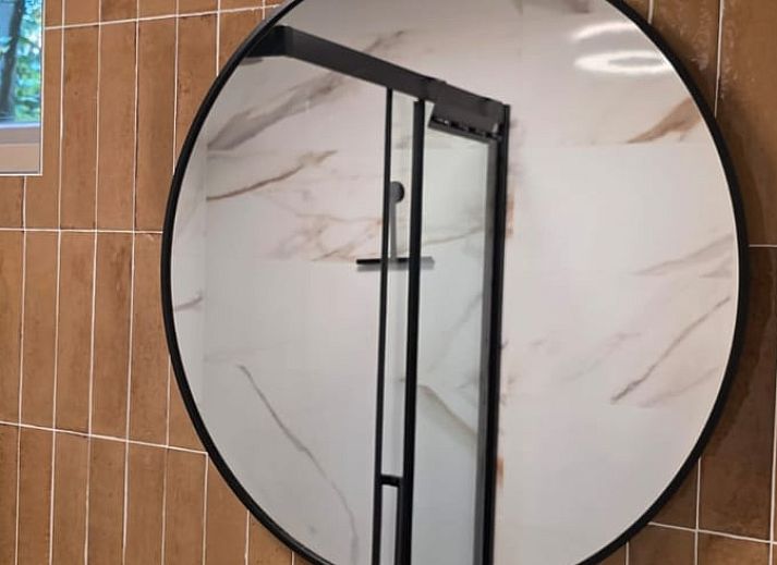 Gezellige binnenruimte van Vakantiehuis in Hoenderloo op de Veluwe, met comfortabele stoel en uitzicht op groene omgeving in Gelderland.