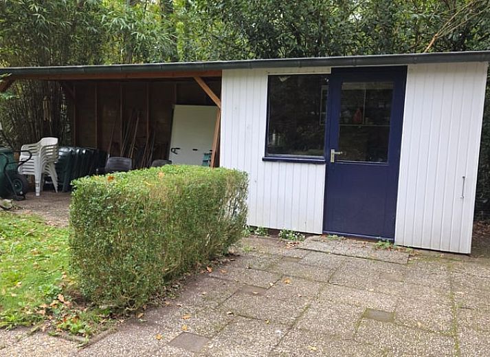 Gezellige binnenruimte van Vakantiehuis in Hoenderloo op de Veluwe, met comfortabele stoel en uitzicht op groene omgeving in Gelderland.