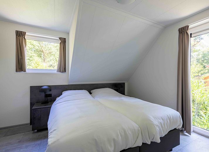 Eetkamer met uitzicht op de tuin in Vakantiehuis Veluwe, Hoenderloo, Veluwe.