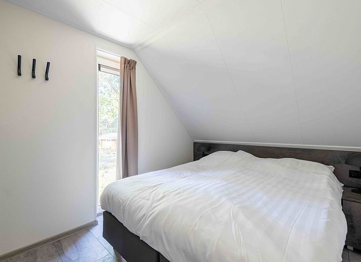 Eetkamer met uitzicht op de tuin in Vakantiehuis Veluwe, Hoenderloo, Veluwe.