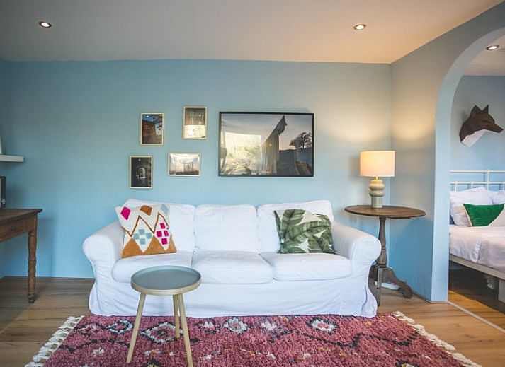 Eetkamer in Vakantiehuisje in Hoenderloo, Veluwe, met uitzicht op de tuin en een uitnodigende sfeer.