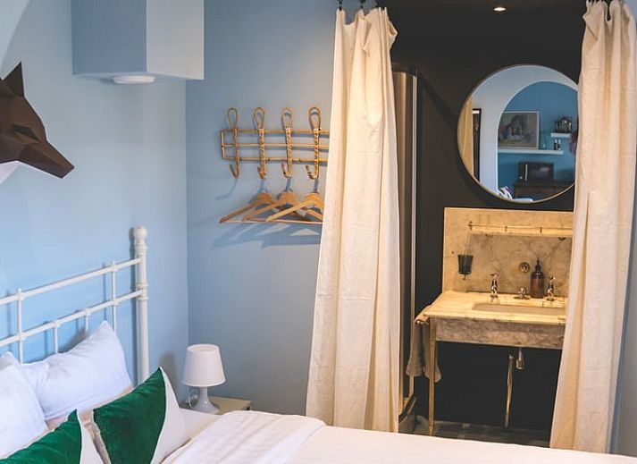 Eetkamer in Vakantiehuisje in Hoenderloo, Veluwe, met uitzicht op de tuin en een uitnodigende sfeer.