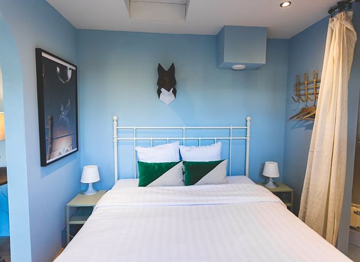 Eetkamer in Vakantiehuisje in Hoenderloo, Veluwe, met uitzicht op de tuin en een uitnodigende sfeer.