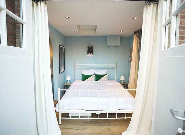 Lichte eetruimte in Vakantiehuisje in Hoenderloo, Veluwe, met toegang tot de tuin en veel natuurlijk licht.