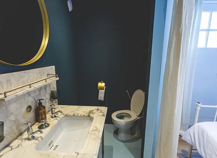 Lichte eetruimte in Vakantiehuisje in Hoenderloo, Veluwe, met toegang tot de tuin en veel natuurlijk licht.