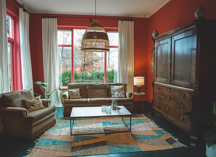 Buitenkant van Vakantiehuis in Hoenderloo, omringd door groene natuur op de Veluwe.