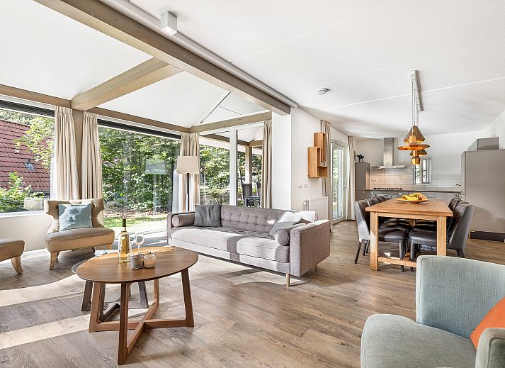 Dining room in Miggelenberg bungalow, Hoenderloo, Veluwe, Gelderland, with large wooden table.
