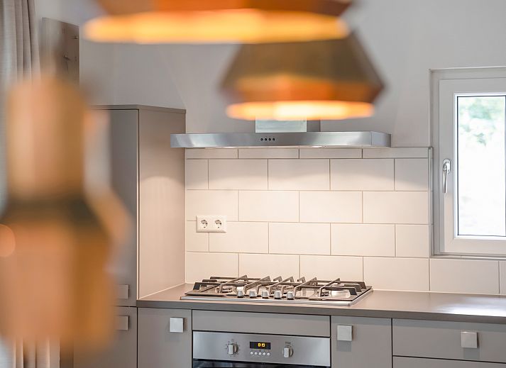 Dining room in Miggelenberg bungalow, Hoenderloo, Veluwe, Gelderland, with large wooden table.