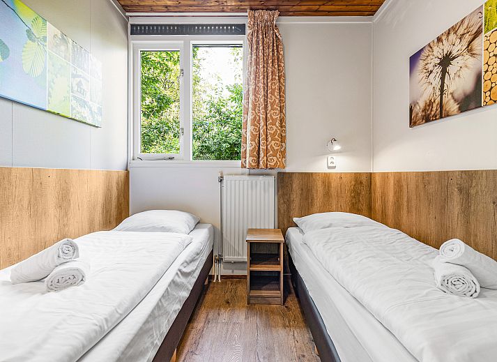 Sfeervolle woonkamer met houtkachel in Miggelenberg 8-persoons bungalow 8C, Hoenderloo, Veluwe.